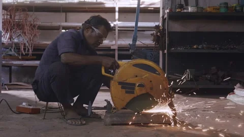 Indian male worker using a chop saw to cut a metal rod in a workshop Stock-Footage 339147573