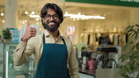 Indian man in apron cafe worker male Arabian waiter smiling small business owner Stock-Footage 241317548