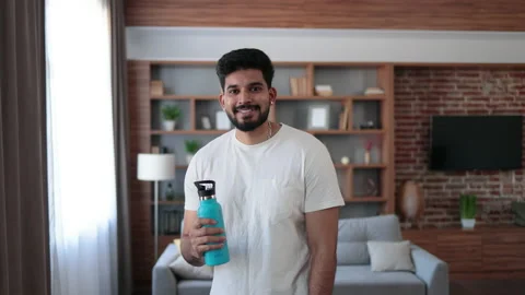 Indian man with bottle of water posing at living room Stock Footage 236495203