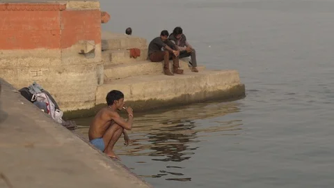 An Indian man brushes his teeth on the Ganges river Stock Footage 112335891