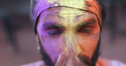 Indian man close-up of face smeared with bright Holi colors Stock Footage 125375350