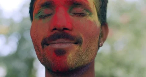 Indian man close-up of face smeared with bright Holi colors Stock Footage 125378026