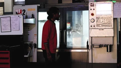 Indian man closing machine door and doing programing on CNC machine. 動画素材 240079863
