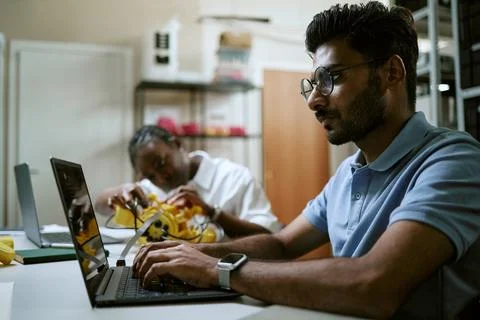 Indian Man Coding on Laptop during Robotics Engineering Workshop Stock Photos