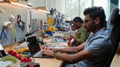 Indian Man Coding Robotics Software on Laptop in Tech Laboratory Stock Footage 343502794