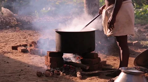 Indian man cooking in a cauldron Stock Footage 49322106