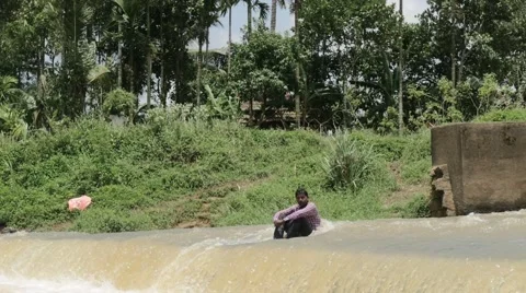 Indian man cooling himself in river Stock Footage 59824372