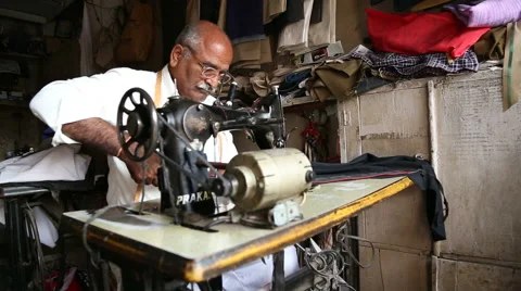 Indian man cutting textile with scissors at sewing workshop in Jodhpur. Stock Footage 50067726