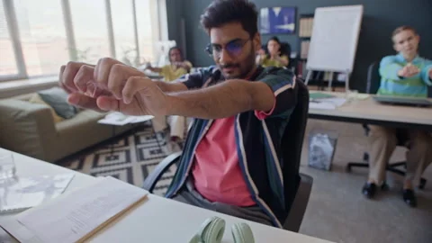 Indian Man with Diverse Colleagues Doing Wrist Stretching in Office 스톡 동영상 338334793