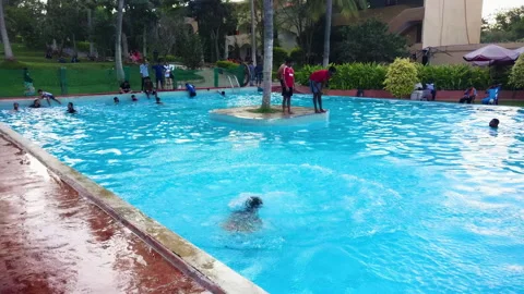 Indian Man Diving into Pool at Resort in Bangalore, Vibrant Vacation Vibe Stock Footage 320767564