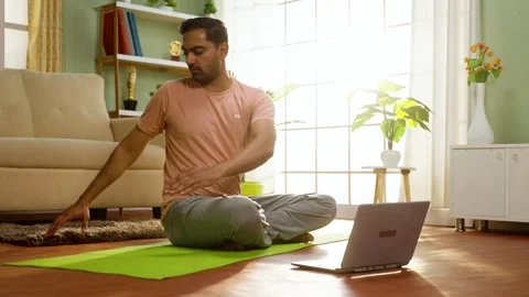 Indian man doing exercise by watching yoga video tutorial or online class from Vídeos de archivo 246370808