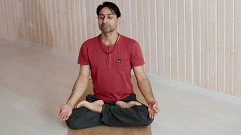 Indian man doing yoga while inside the house on the floor. Stock Footage 151720394