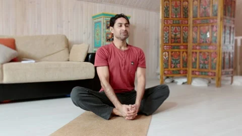 Indian man doing yoga while inside the house on the floor. Stock Footage 151720409