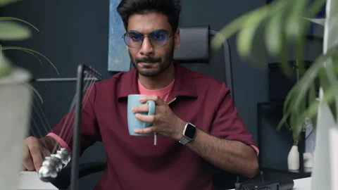 Indian Man Drinking Coffee and Working at Modern Office Desk Stock Footage 338330792