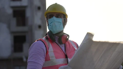 Indian man engineer matching details with blue prints on site. Video stock 161815079