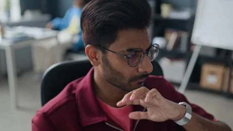 Indian Man with Glasses Thinking and Playing with Baseball in Office Stock Footage 338331120
