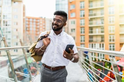 Indian man installing innovative software on digital smartphone with coffee t 写真素材
