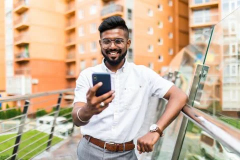 Indian man installing innovative software on digital smartphone with coffee t 写真素材