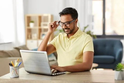 Indian man with laptop working at home office Stock Photos