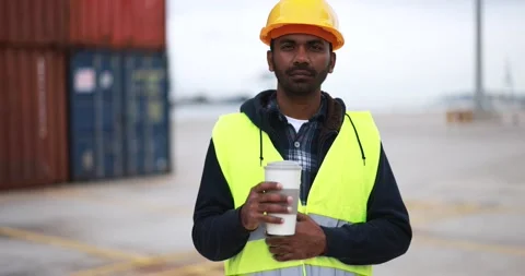 Indian man looking on camera working with industrial port on background Stock Footage 179971467
