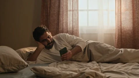 Indian Man Lying in Bed and Using Smartphone in Morning Stock Footage 337713201