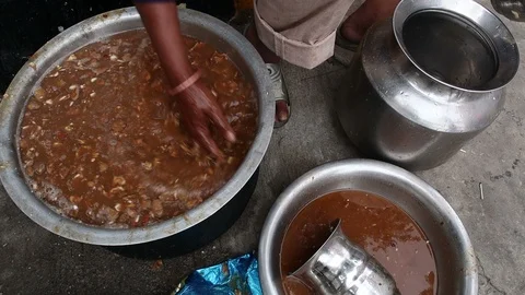 Indian-man-makes-tamarind-pulp-in-large-vessel Stock Footage 93378471