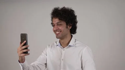 Indian man making a video call smiling and talking with her friend and family. Видео 169907809