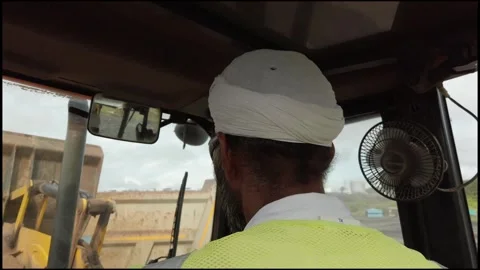 An Indian man operating a backhoe loader at a construction site  Video stock 314008770