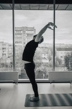 Indian man practicing yoga in doors, european city at background Stock Photos