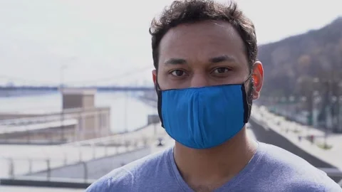 Indian man in protective face mask looking at camera standing outdoors 库存影片 152108756