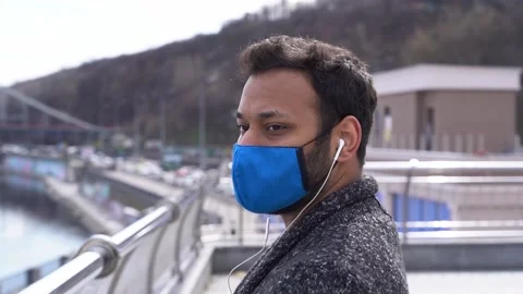 Indian man in protective face mask listening to music walking on the street Stock-Footage 152793285
