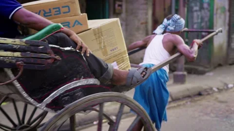 Indian man is pulling a rickshaw carrying a person with luggage. Stock Footage 267059907