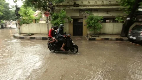 Indian man rides a scooter in rain Stock Footage 94906363