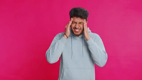 Indian man rubbing temples to cure headache problem, suffering from tension and Stock Footage 310481135
