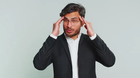 Indian man rubbing temples to cure headache problem, suffering from tension and Stock Footage 315851235
