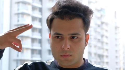 Indian man shoots himself playfully with hand gestures as a gun on his forehead  Stock Footage 100618067