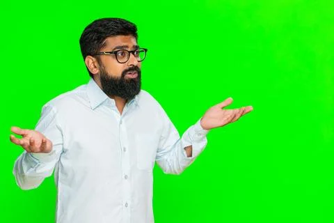 Indian man shrugging with puzzled expression making hands up gesture expressing Stock Photos