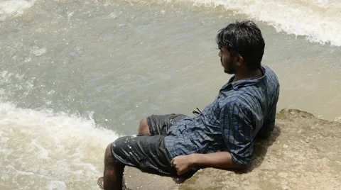Indian man sitting on dam Stock Footage 59823343