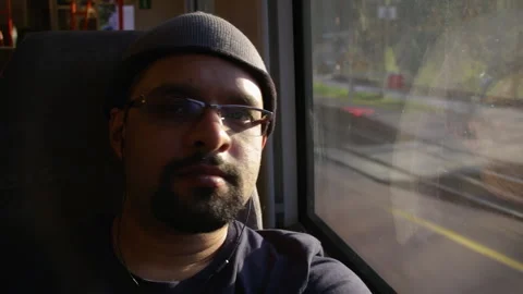 Indian Man Sitting by Train Window in Evening Sunlight on Bergen Railway, Norway Stock Footage 342019918