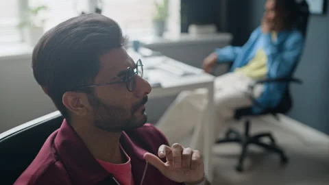 Indian Man Squeezing Baseball during Creative Office Brainstorming Stock Footage 338330399