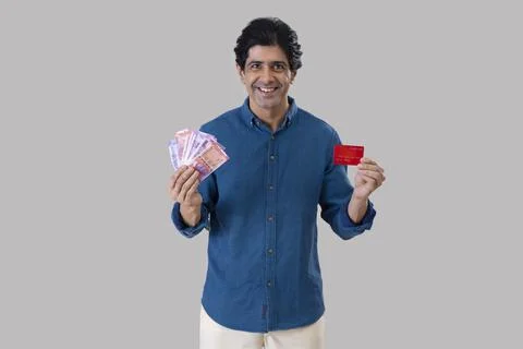 Indian man standing in front of camera with holding a credit card and Indian  Stock Photos