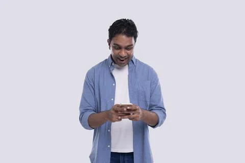 Indian Man Standing Using Phone Over Exceeded Isolated. Man Texting on Phone Stock Photos
