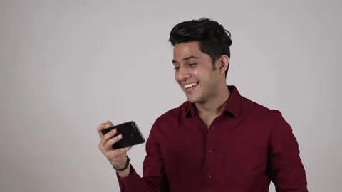 Indian man standing while using smart phone watching funny video. Stock-Footage 169908448