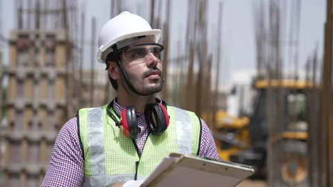 Indian man takes notes in front of building under construction site. Видео 162014980