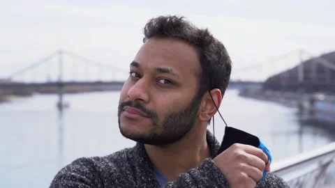 Indian man taking off protective face mask, looking at camera, smiling Stock-Footage 152108599