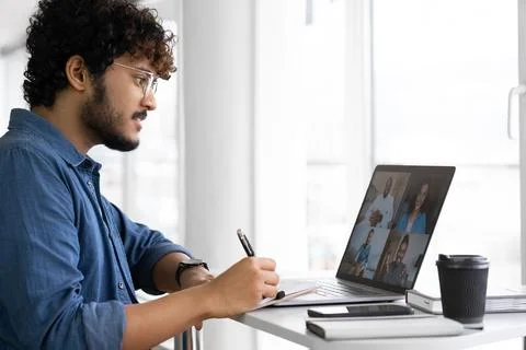 Indian man using app for distance video communication with coworkers via laptop Stock Photos
