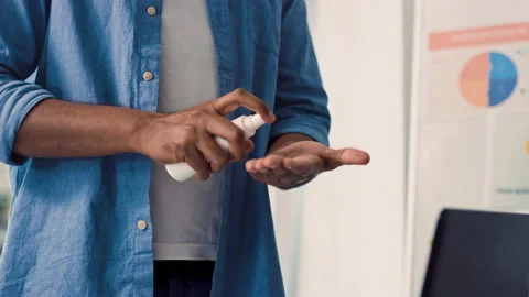 Indian Man Using Hand Antiseptic at Work. Man Using Hand Sanitizer at Creative Stock Footage 217509698