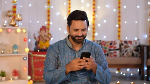 Indian man using a mobile phone - browsing smartphone. Diwali festival celebr... Video stock 217420327