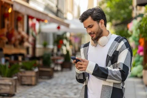 Indian man using smartphone typing text messages in social media application Stock Photos