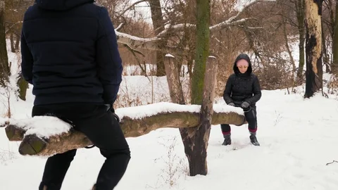 Indian Man in a Warm Hat and Beautiful Woman Ride on a Snow-Covered Swing Stock Footage 101543569